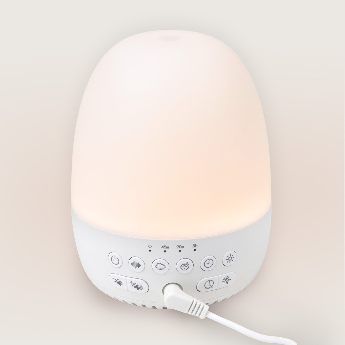 White sound machine with a glowing top on a light beige background