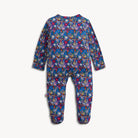 A baby footed one-piece jumpsuit with a dense multicolor floral pattern on a dark blue base, shown flat against a light off-white background.