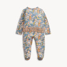 A baby footed one-piece jumpsuit with a blue floral print and a smocked waist, shown flat on a light gray background.