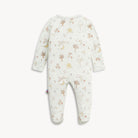A baby footed one-piece jumpsuit in cream white with a delicate all-over print of trees, flowers, and suns in muted brown and soft orange tones, shown against a light off-white background.