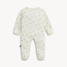 A baby footed sleeper in a soft off-white fabric, featuring a delicate all-over print of small orange flowers and light green leaves, shown from the back against a clean white background.