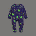A baby's long-sleeve footed sleeper in a deep purple space theme, featuring neon green glowing unicorns, planets, and stars, displayed flat against a solid gray background.