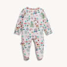 A baby footed sleeper with long sleeves and legs, featuring a colorful winter village print on a white background, shown against a light gray studio backdrop.