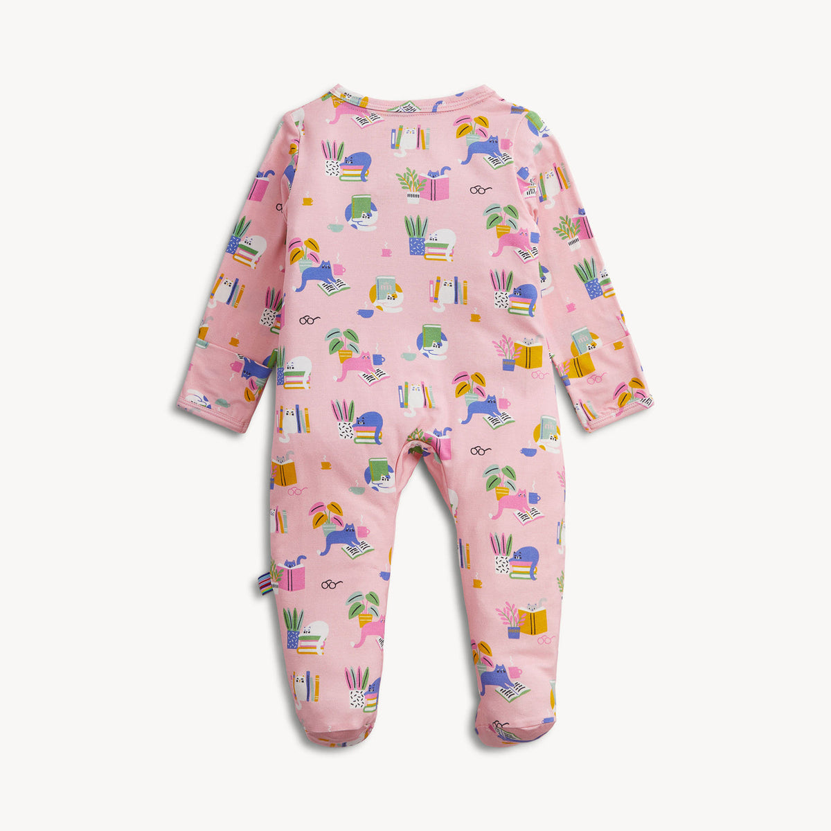 A pink baby footed one-piece jumpsuit with an all-over colorful pattern of school supplies, including pencils, books, rulers, and small unicorn motifs, shown on a light off-white background.