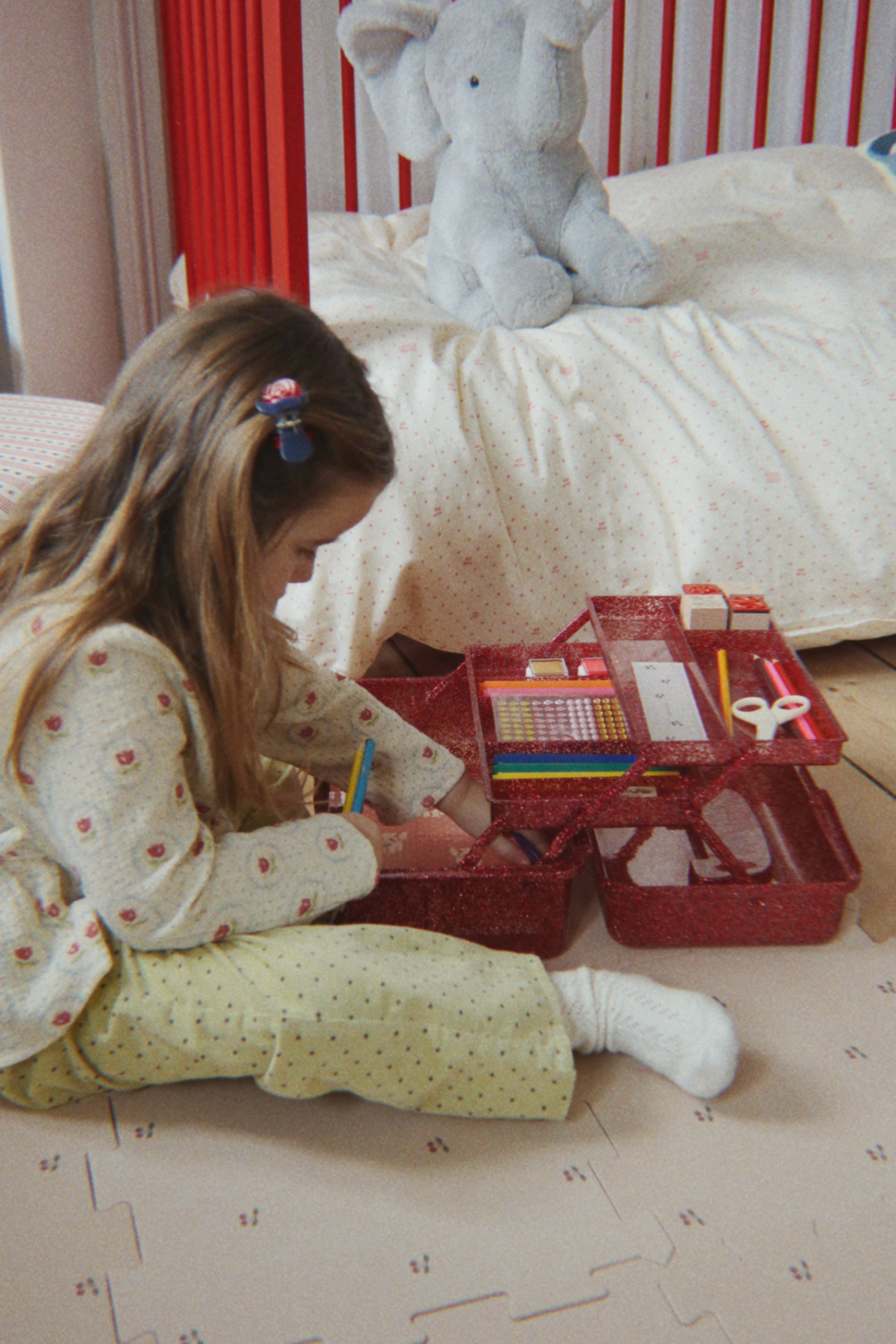 Child playing with a toy box on the floor in a bedroom