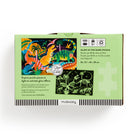 A product photo of the Dinosaur Park 100 Piece Glow in the Dark Puzzle by Mudpuppy box back against a white background, showing the puzzle specifications, dinosaur illustrations, and instructions to expose the puzzle pieces to light.