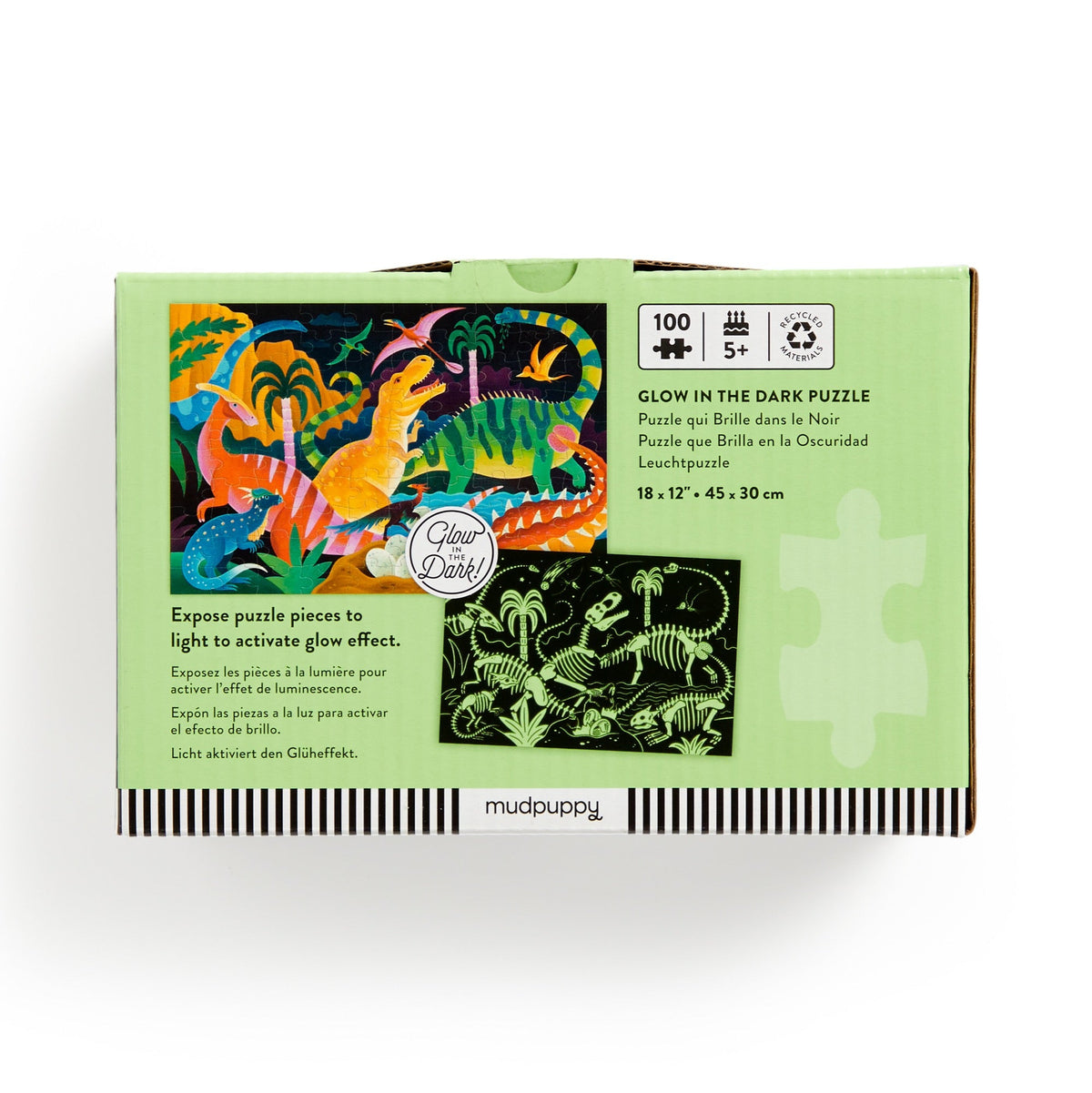 A product photo of the Dinosaur Park 100 Piece Glow in the Dark Puzzle by Mudpuppy box back against a white background, showing the puzzle specifications, dinosaur illustrations, and instructions to expose the puzzle pieces to light.