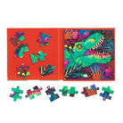 Dinosaurs Roar! Magnetic Puzzle Set open on a red trifold board, showing a partially completed green dinosaur puzzle alongside loose puzzle pieces scattered on the surface.