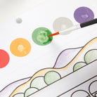 Colorful circles on a piece of paper with a brush adding color.