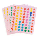 Several sheets of holographic stickers from the Mudpuppy Christmas Cheer Sticker Sparkle Poster Activity Kit, featuring sparkling geometric and floral designs in vibrant holiday colors like red, green, gold, blue, and pink.