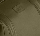 Close-up of a green bag with a brand logo on a matching background