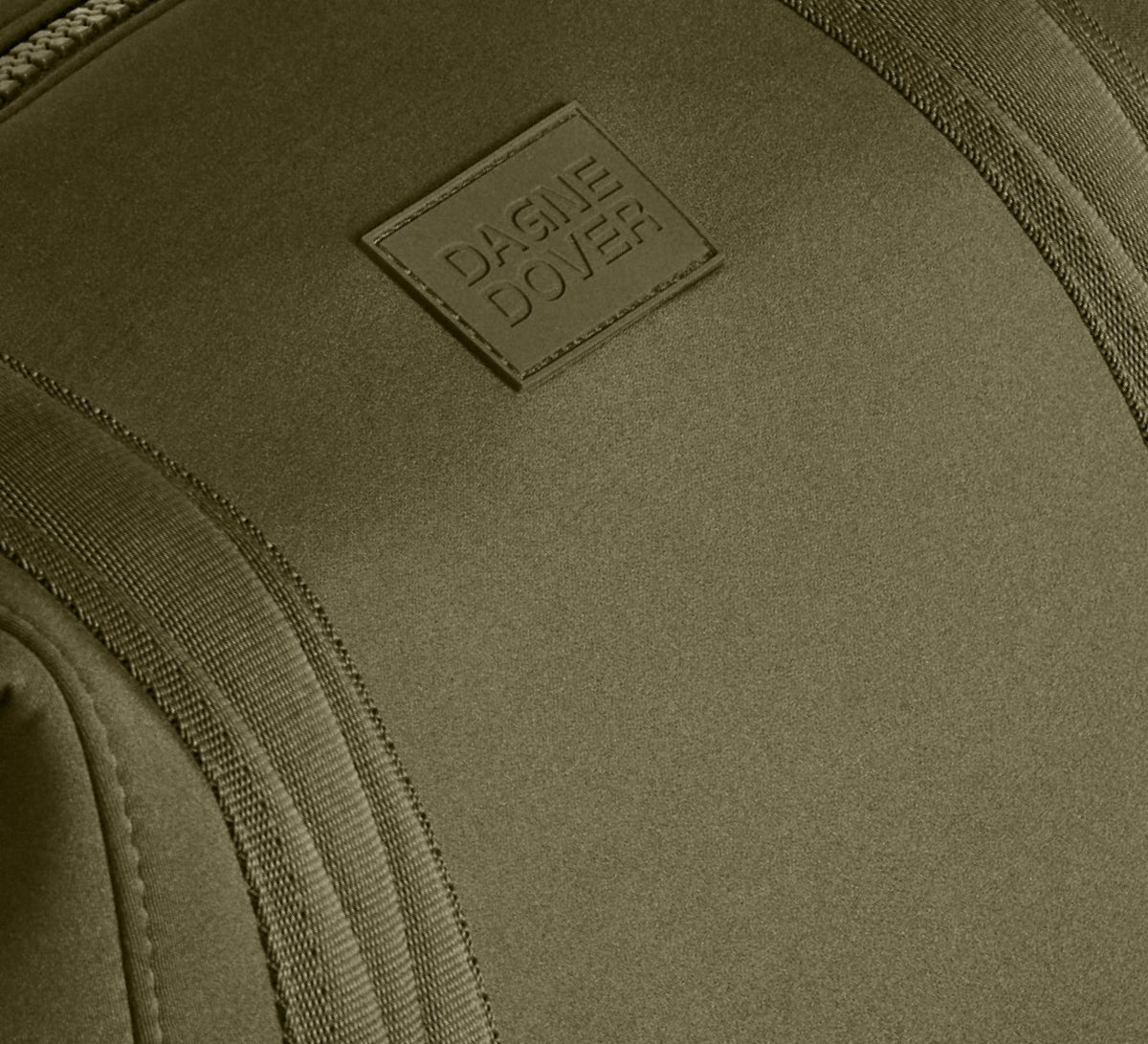 Close-up of a green bag with a brand logo on a matching green background