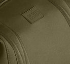 Close-up of a green bag with a brand logo on a matching green background