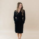Woman wearing a black dress against a beige background