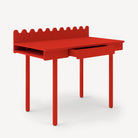 Red children's desk with a scalloped edge on a white background