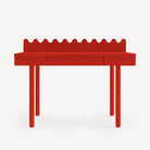 Red children's desk with scalloped edge on a white background