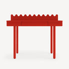 Red console table with a scalloped edge on a white background