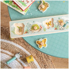 Children's puzzle with animal-themed wooden pieces on a green cutting mat.