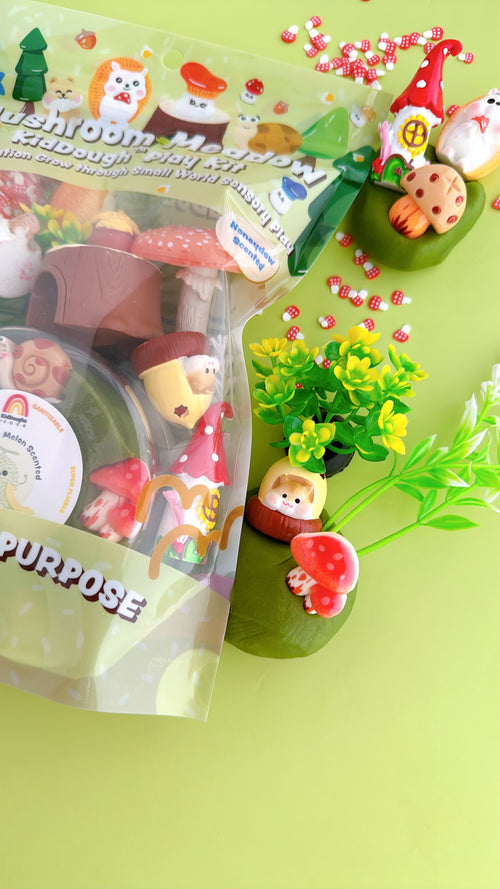 Fimo clay figures of gnomes and mushrooms on a green surface with packaging.
