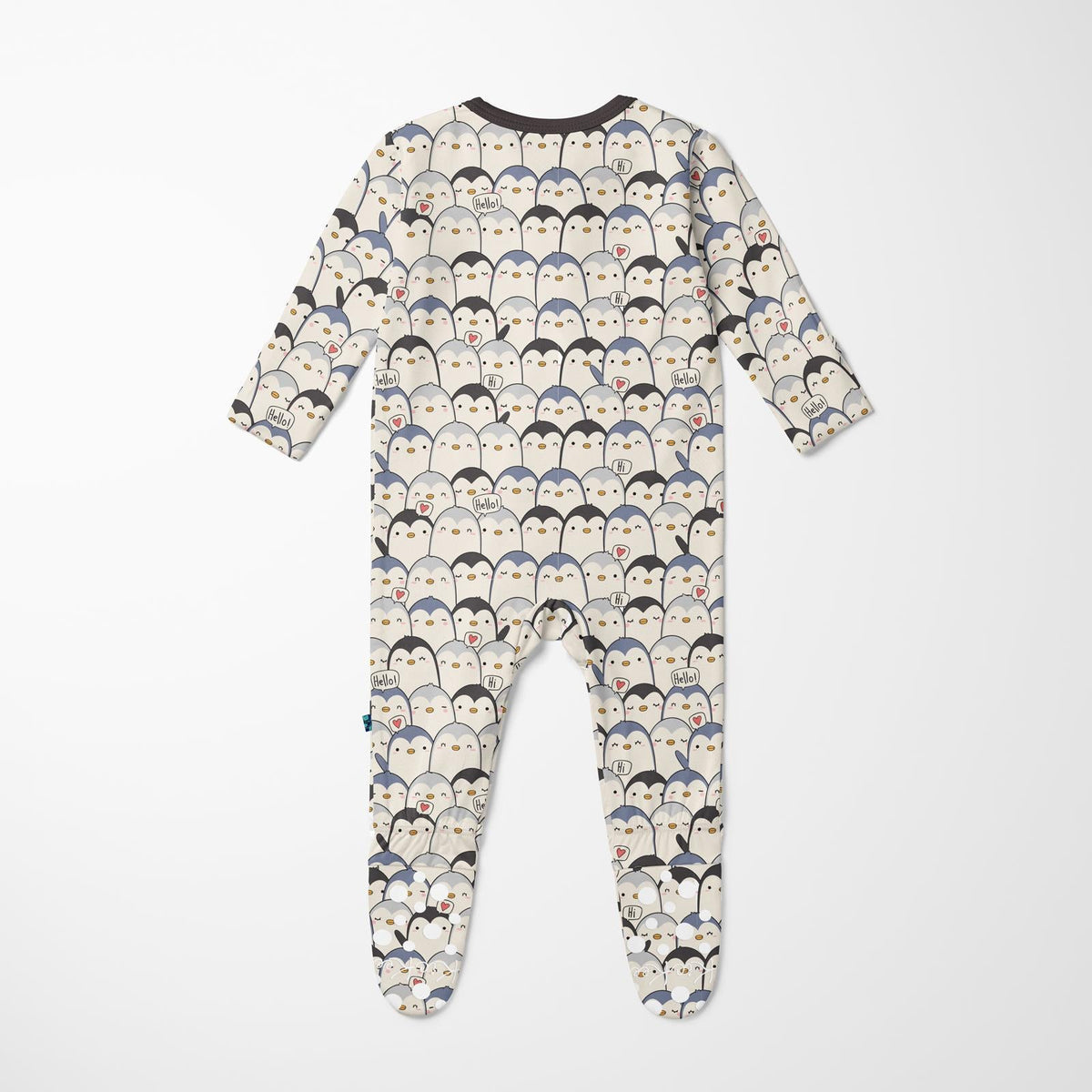 A baby footed sleeper with long sleeves and an all-over penguin print on a cream background, shown flat against a light gray background.