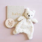 A cream-colored, curly teddy bear plush toy with small black embroidered eyes and nose on a white background.