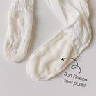 White socks with soft fleece foot pads on a light gray background