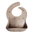 Beige silicone bib with animal prints on a white background