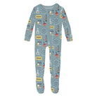 A baby footed one-piece jumpsuit in dusty blue, featuring an all-over print of carnival games, Ferris wheels, and popcorn buckets.
