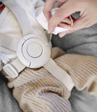 Close-up of a baby seat with a hand cleaning it using a cloth.