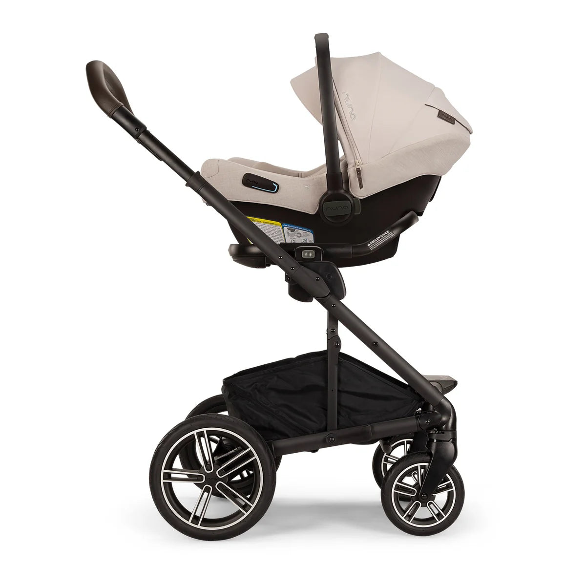 A profile view of a MIXX Next + Pipa Aire RX Travel System by Nuna in Biscotti featuring a beige infant car seat attached to the black stroller frame, with a brown leatherette handlebar, set against a clean white background.
