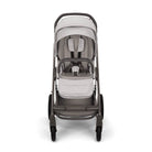 A stroller with a light gray and taupe-gray color scheme, featuring a textured fabric canopy, seat pad, and matching footmuff, set against a plain white background.