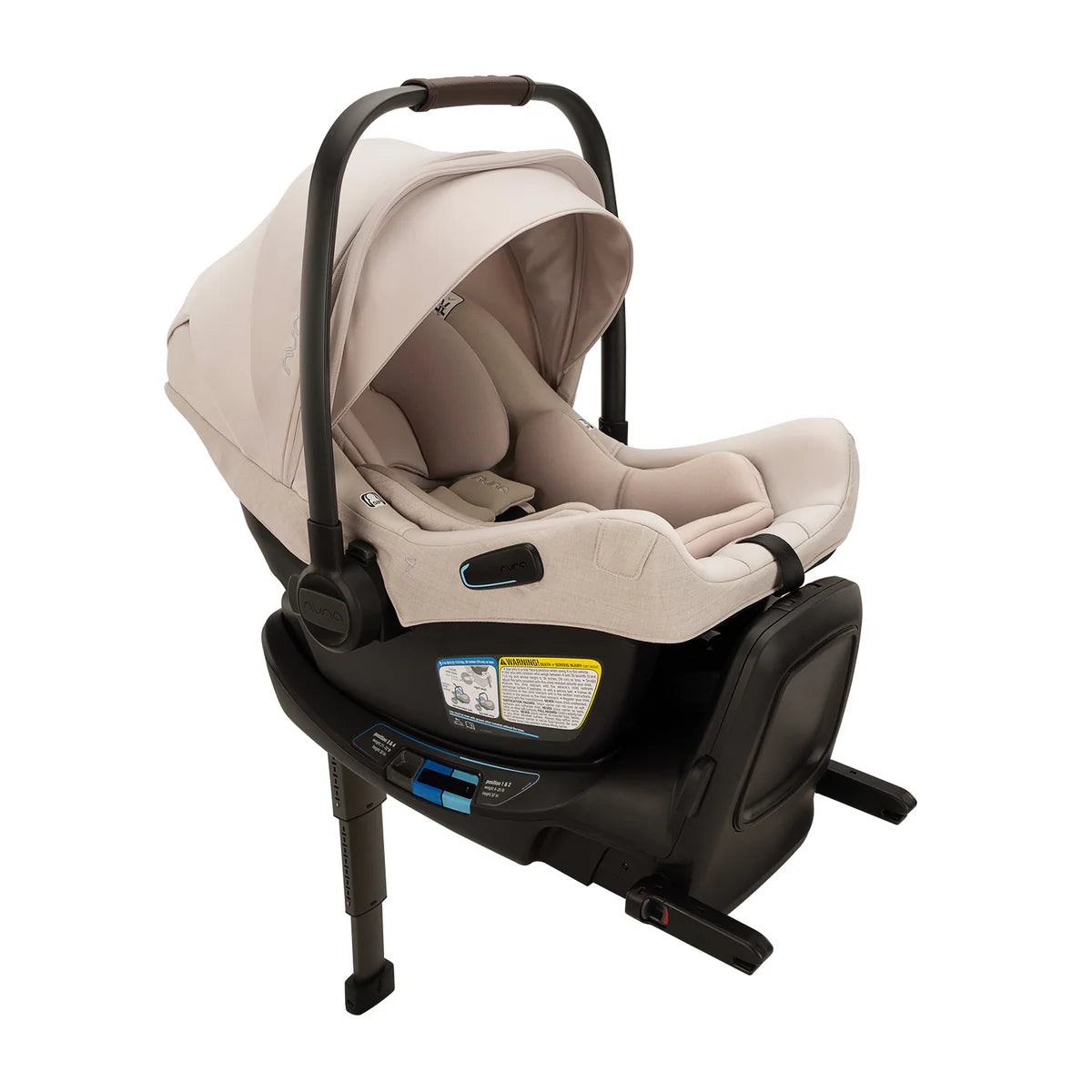 A profile view of a MIXX Next + Pipa Aire RX Travel System by Nuna infant car seat in Biscotti attached to its base with a load leg, featuring a beige seat and canopy and a brown leatherette carry handle, set against a clean white background.