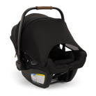 A profile view of a black MIXX Next + Pipa Aire RX Travel System by Nuna infant car seat featuring an exposed aerospace aluminum handle and an extended canopy, set against a checkered transparent background.