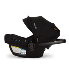 A profile view of a black MIXX Next + Pipa Aire RX Travel System by Nuna infant car seat featuring an exposed aerospace aluminum handle, set against a checkered transparent background.
