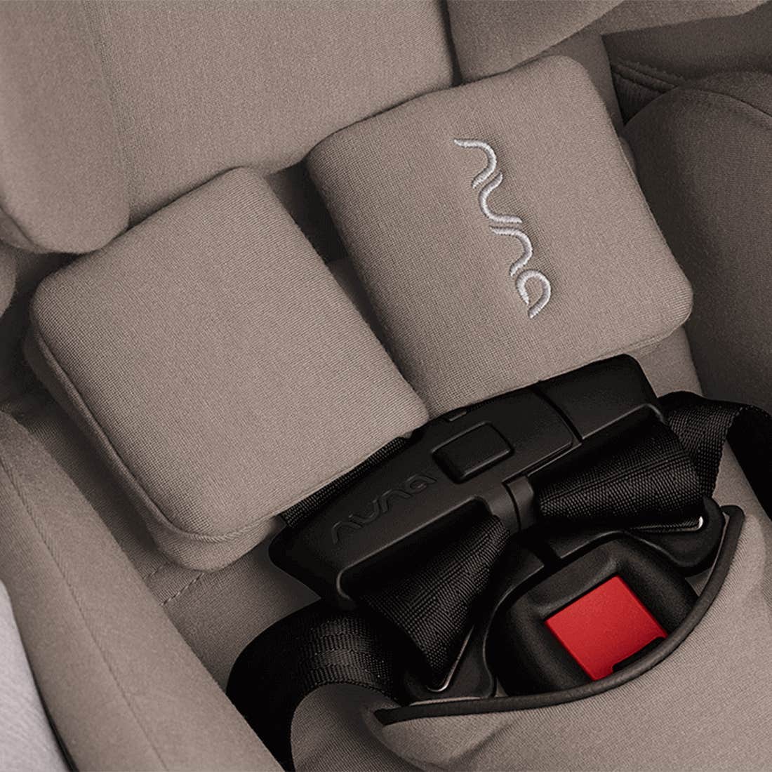 Gray car seat with Nuna logo and black and red straps.