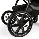Close-up of a black stroller wheel on a white background