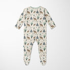 A baby footed sleeper with long sleeves and an all-over woodland print featuring deer, moose, pine trees, and small cabins on a cream background, shown flat against a light gray background.