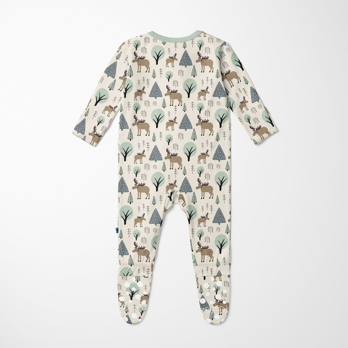 A baby footed sleeper with long sleeves and an all-over woodland print featuring deer, moose, pine trees, and small cabins on a cream background, shown flat against a light gray background.