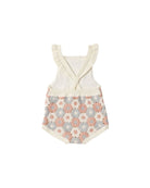Baby romper with floral patterned bottom and white top on a white background