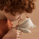 Child holding a soft toy against a warm brown background