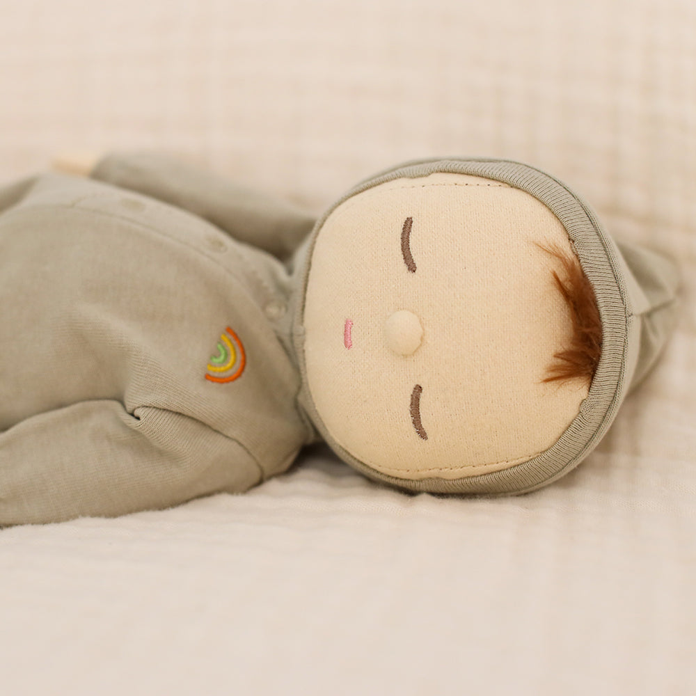 Toy resembling a baby with a smiling face on a soft surface