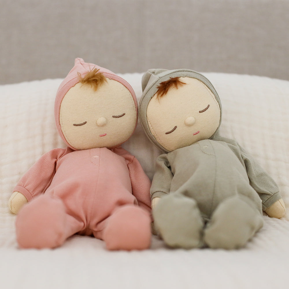 Two plush toys, one in pink and one in gray, sitting on a white surface.