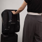Person holding a black backpack with 'DWAY' branding against a plain background