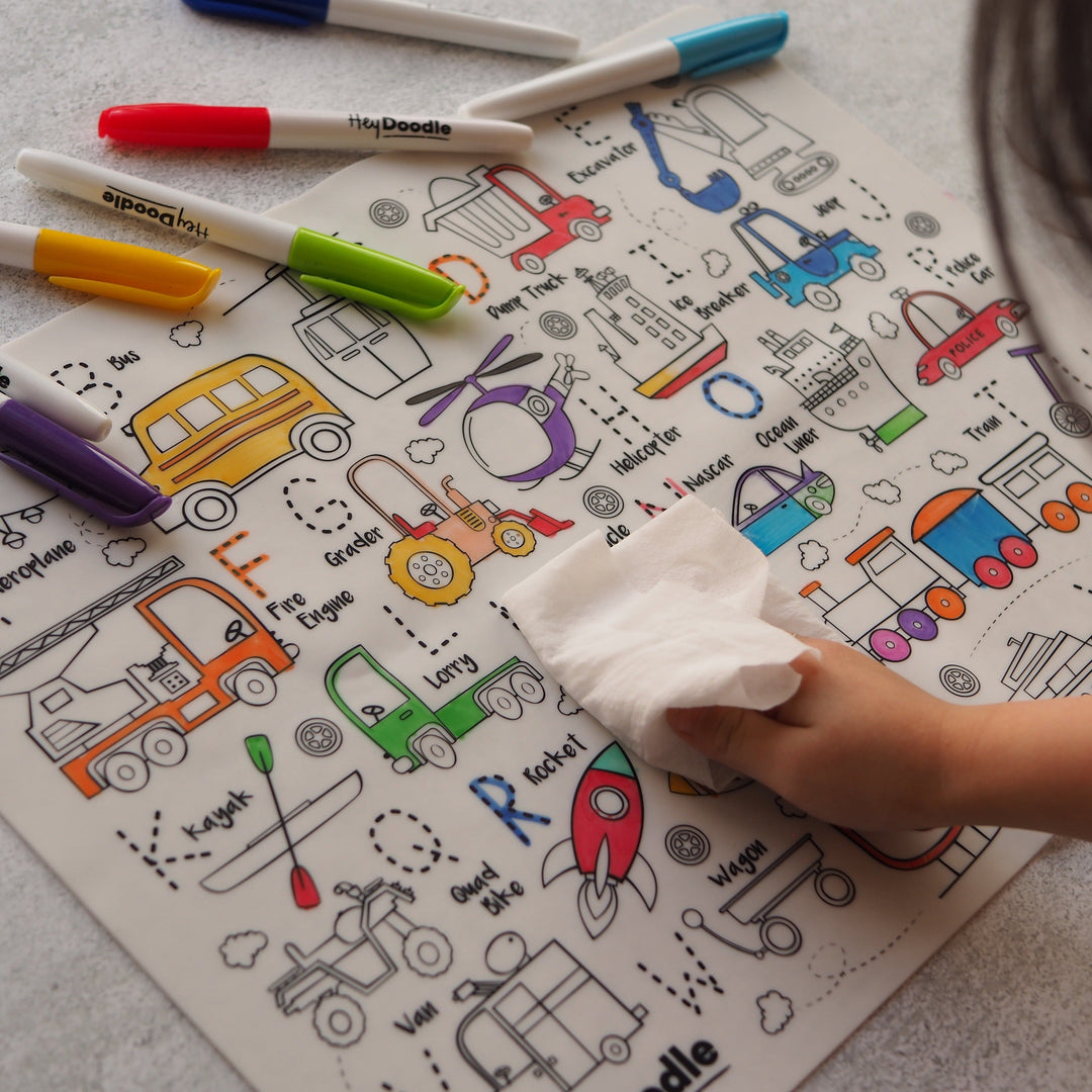 Colorful children's activity mat with markers and a hand wiping it.
