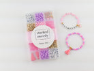 Princess Party DIY Bracelet Kit featuring a compartment storage box with a "stacked sweetly - Princess Party" label, filled with colorful beads, alphabet letter beads, and charms next to two completed pink, purple, and gold beaded bracelets, including one spelling "PRINCESS" with a small crown and tassel charm.