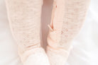 Close-up of a baby's feet in pink socks on a light background