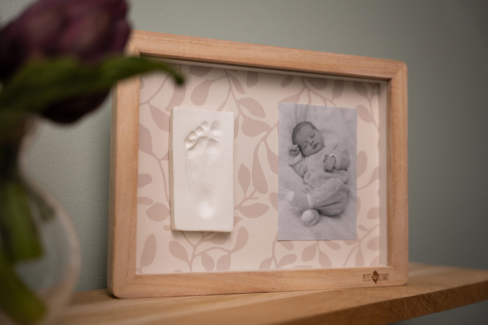 Wooden photo frame with a baby photo on a shelf