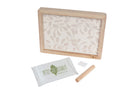 Wooden frame with patterned paper, Petit Pitcheau packaging, and wooden tool on a white background