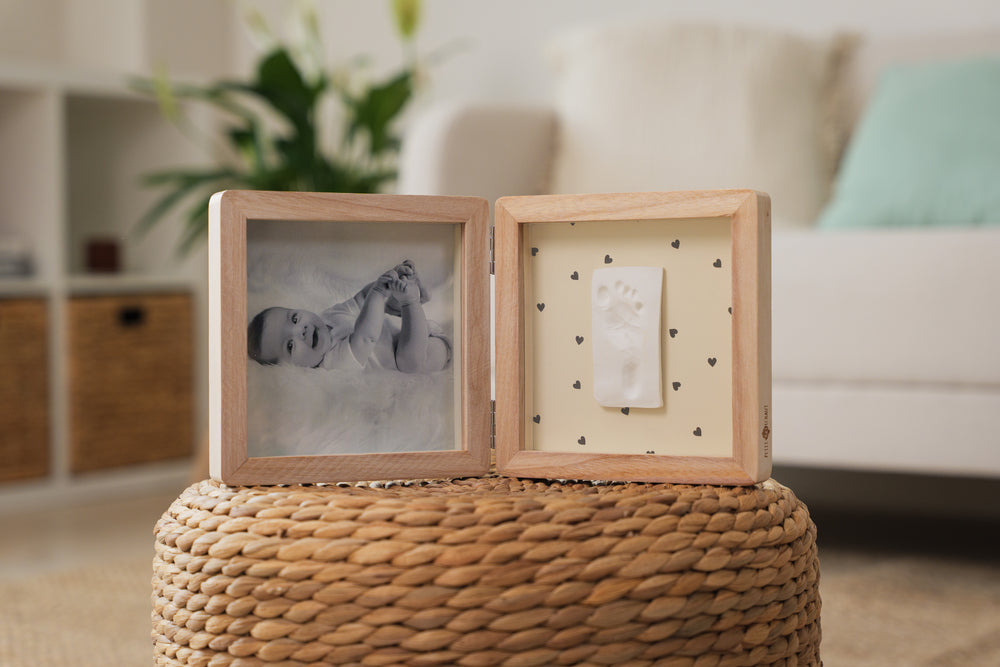 Wooden photo frame with baby photo on a textured surface