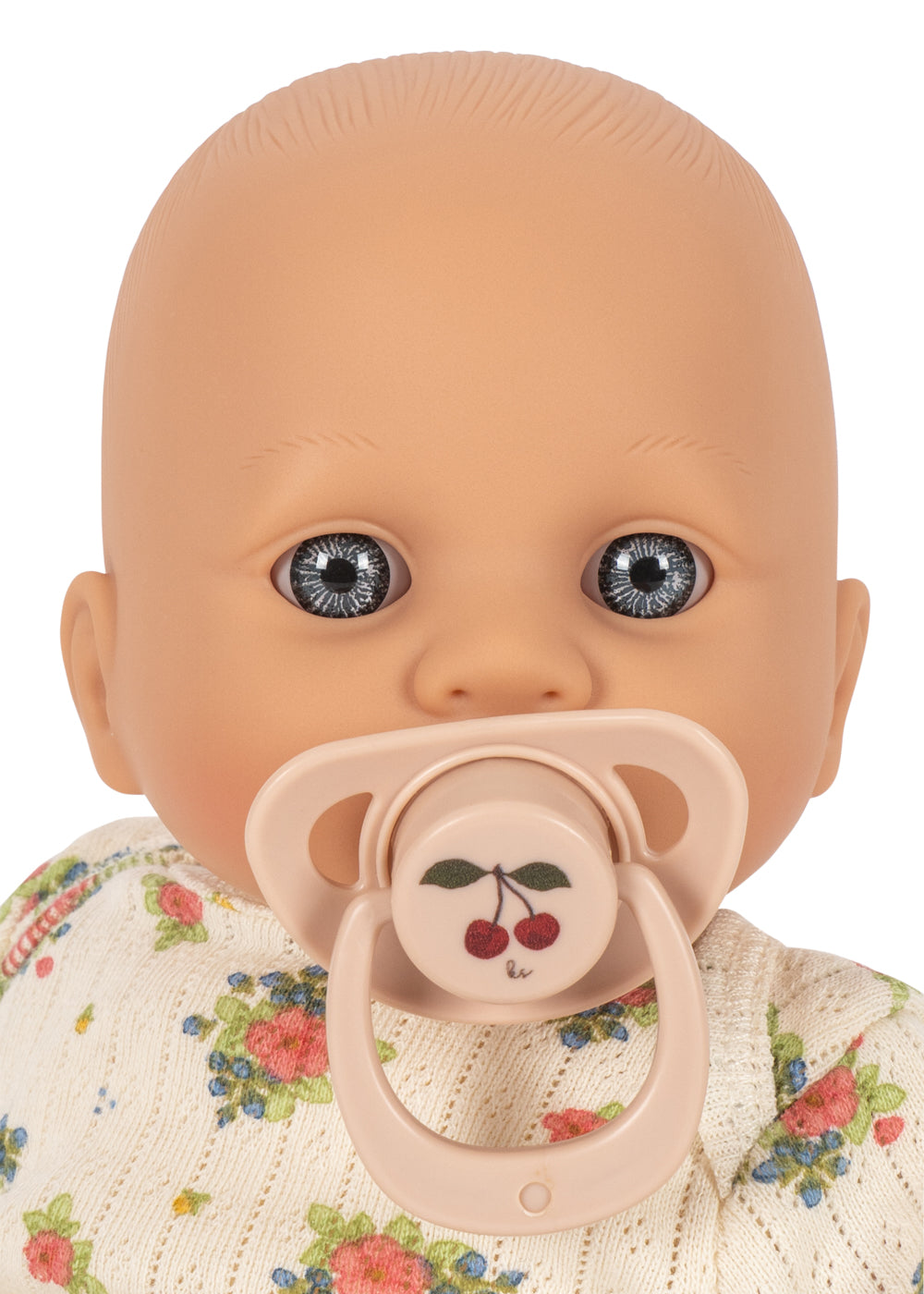 Baby doll with a pacifier and floral outfit on a white background